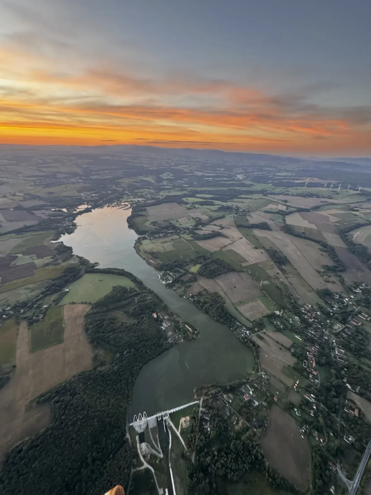 Panorama rzeki i pól z lotu motoparalotnią